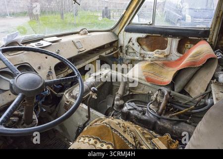 Die Innenansicht eines alten Lastwagens zeigt das Lenkrad und abgenutzte Sitze, fahrtüchtig, Van, JerAZ-762 oder ErAZ-762, Armenien Stockfoto