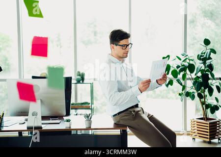 Selbstbewusstes professionelles Prüfen von Dokumenten in einer modernen Büroumgebung, die professionelle Führung und elegante Eleganz verkörpert. Stockfoto