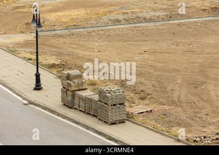Verlegung von Pflasterplatten und -Begrenzungen auf der Baustelle, Hochwinkelansicht Stockfoto