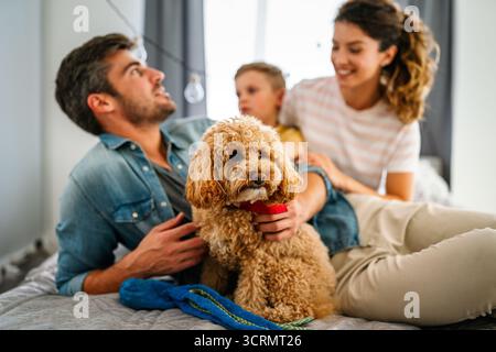 Glückliche multiethnische Familie, die zu Hause Spaß hat, Eltern, Kind und Hund verbringen gute Zeit zusammen Stockfoto