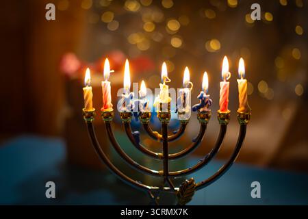 Eine Menora mit neun zündeten Kerzen vor einem sanften, leuchtenden Bokeh-Hintergrund, die Wärme und Frieden zur Feier von Hanukka weckt. Selektiver Fokus. Stockfoto