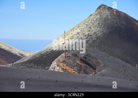 La Palma Tajogaite-Vulkan Tajogaite-Vulkan auf La Palma. Der Tajogaite-Vulkan entstand durch einen schnellen dreimonatigen Vulkanausbruch von September bis Dezember 2021. Durch den Vulkanausbruch wurde eine große Zahl von Haeusern in Doerfern und Siedlungen der Gemeinden El Paso, Los Llanos de Aridane und Tazacorte zerstoert und weite Teile landwirtschaftlich genutzter Flaeche mit Lava und Asche bedeckt. Mittlerweile darf in einem Teil der Gegend um den Vulkan in Begleitung von Orts- und fachkundiger Leitung wieder gewandert werden, wenn die Gaskonzentration in der Gegend gering ist. Im Bild: Schw Stockfoto