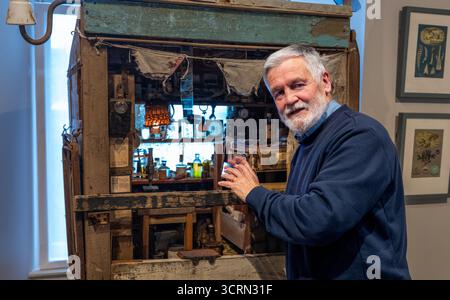 The Scottish Gallery, Edinburgh, Schottland, Vereinigtes Königreich, 02. Oktober 2025, 50 Jahre Naboland und die Familie Behrens: Reinhard Behrens hat in seinen Gemälden seit 50 Jahren in einer neuen Ausstellung ein alternatives Universum geschaffen, Naboland. Das mythische Land Naboland bietet U-Boot-Expeditionen, traumhafte Meereslandschaften und fantasievolle Kartographien. Im Bild: Reinhard Behrens mit einer von ihm geschaffenen Miniaturszene aus Naboland. Quelle: Sally Anderson/Alamy Live News Stockfoto