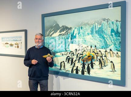 The Scottish Gallery, Edinburgh, Schottland, Vereinigtes Königreich, 02. Oktober 2025, 50 Jahre Naboland und die Familie Behrens: Reinhard Behrens hat in seinen Gemälden seit 50 Jahren in einer neuen Ausstellung ein alternatives Universum geschaffen, Naboland. Das mythische Land Naboland bietet U-Boot-Expeditionen, traumhafte Meereslandschaften und fantasievolle Kartographien. Im Bild: Reinhard Behrens mit einigen seiner Kunstwerke und seinem 50 Jahre alten Spielzeug-U-Boot. Quelle: Sally Anderson/Alamy Live News Stockfoto