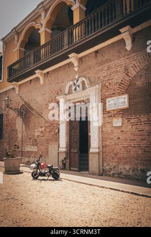 Historisches Gebäude mit gewölbtem Balkon und Motorrad in Lima, Peru. Stockfoto