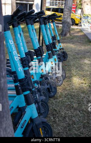 ANTALYA, TÜRKEI - 12. NOVEMBER 2024 - Linie der blauen Elektroroller zum Vermieten oder Vermieten Stockfoto