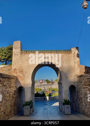 Historischer Steinbogen, der Tanger Kasbah mit dem Yachthafen verbindet. Antike Architektur trifft auf modernes Stadtbild. Fotografiert Am 1. Oktober 2025. Stockfoto
