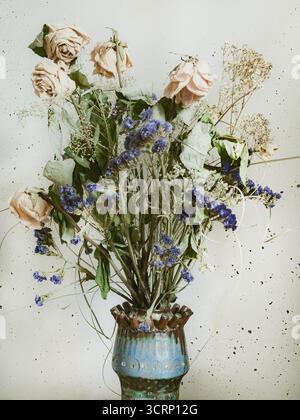 Stillleben mit gemischtem Blumenstrauß der trockenstaubigen verblassten Blüten in Vintage-Vase Stockfoto