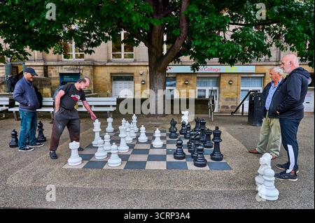 Spielen auf einem riesigen Schachbrett auf dem Platz vor dem PINC College und der Zentralbibliothek, Leeds, Großbritannien Stockfoto