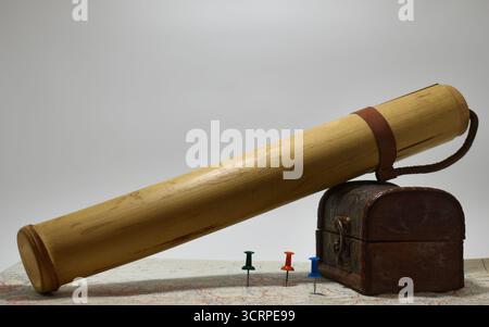 Abbildung einer Karte mit Pins an verschiedenen Stellen, mit einer kleinen Brust und einer Röhre zum Speichern der Karte Stockfoto