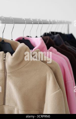 Fleece-Pullover an Kleiderbügeln. Mode, Online-Shops, saisonale Bekleidungskollektionen. Stockfoto