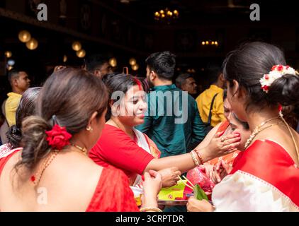 Neu-Delhi, Delhi, Indien. Oktober 2025. Auf VIJAYA DASHAMI tauchen Frauen während des traditionellen Sindoor-Khela-Rituals im CR PARK KALIBARI in NEU-DELHI in die Welt von Zink ein. Die Praxis, in der verheiratete Frauen sich vor dem Eintauchen der Göttin Durga mit Sindoor beschmutzen, symbolisiert Wohlstand und gemeinsamen Abschied von der Göttin. Der CR Park, der oft als „Mini-Kalkutta“ von Delhi bezeichnet wird, beherbergt eine der bekanntesten Durga Puja-Feiern außerhalb Bengals. (Kreditbild: © Shubhadeep Mukherjee/ZUMA Press Wire) NUR REDAKTIONELLE VERWENDUNG! Nicht für kommerzielle ZWECKE! Stockfoto