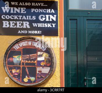 Barschild mit einer Auswahl an alkoholischen Getränken, einschließlich Wein, Gin, Bier und Cocktails neben einer grünen Tür Funchal Madeira Stockfoto