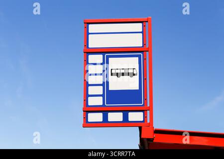Schild mit Bushaltestelle am blauen Himmel. Öffentliche Verkehrsmittel und Reiseinfrastruktur. Städtische Mobilität und Pendelverkehrssystem. Navigation in der Stadt. Stockfoto