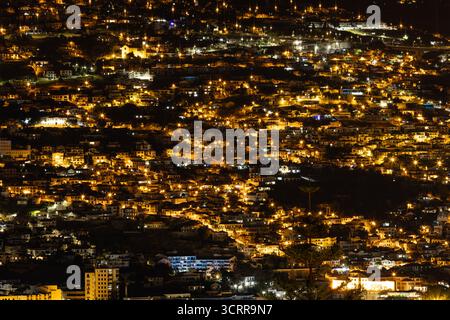 Nächtlicher Blick auf Funchal Stadt Madeira mit unzähligen Gebäuden und Straßenlaternen, die eine lebendige, leuchtende Stadtlandschaft schaffen Stockfoto