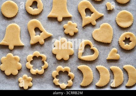 Formen aus rohem Teig auf Backpapier - hausgemachte Linzer Weihnachtskekse Stockfoto