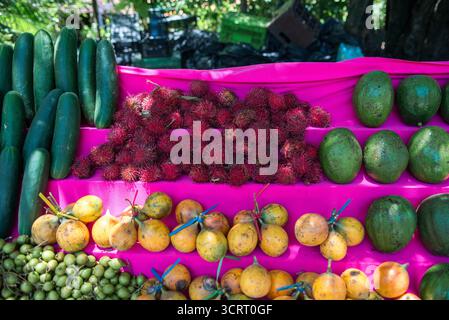 Farbenfrohe Präsentation frischer Gurken Rambutans Passionsfrucht und Avocado auf dem Markt Stockfoto