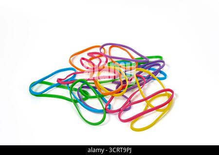 Ein Haufen lebendiger, mehrfarbiger Gummibänder. Ein abstraktes Konzept für Flexibilität, Kreativität, Bürobedarf oder organisiertes Chaos. Stockfoto