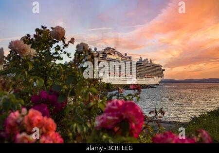 Das Kreuzfahrtschiff liegt im Hafen von Salish Sea vor dem Hintergrund eines Abendhimmels mit wunderschönen Wolken im Hafen von Victoria, BC, Kanada Stockfoto