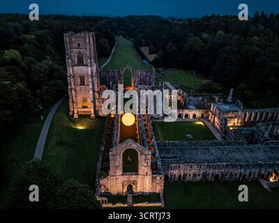 Helios, eine sieben Meter hohe Sonnenskulptur und Soundlandschaft von Luke Jerram, hängt im Schiff der beleuchteten Abteiruinen der Fountains Abbey in der Nähe von Aldfield, Ripon in North Yorkshire. Bilddatum: Donnerstag, 2. Oktober 2025. Stockfoto