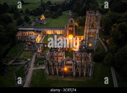 Helios, eine sieben Meter hohe Sonnenskulptur und Soundlandschaft von Luke Jerram, hängt im Schiff der beleuchteten Abteiruinen der Fountains Abbey in der Nähe von Aldfield, Ripon in North Yorkshire. Bilddatum: Donnerstag, 2. Oktober 2025. Stockfoto