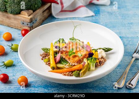 Gebratenes Lachsfilet mit Getreide und Gemüse der Saison Stockfoto