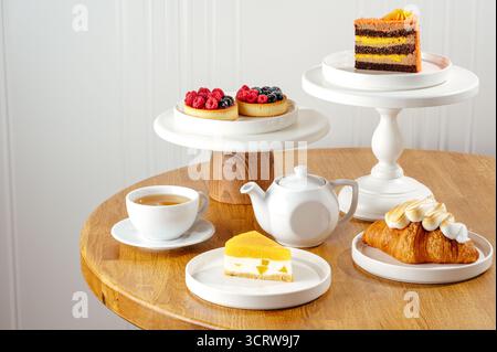 Käsekuchen, Croissant, Tartlet mit Beeren und Tee Stockfoto