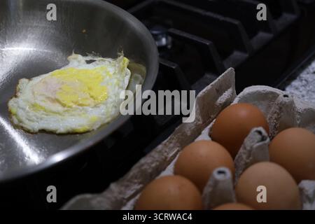 Edelstahl Pfanne Braten Ei neben braunen Eiern im Karton Stockfoto
