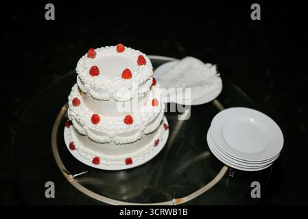 Eleganter dreistöckiger Hochzeitstorte mit Himbeeren Stockfoto