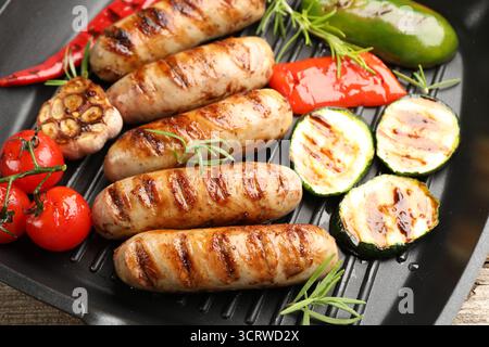 Pfanne mit gegrillten Würstchen, Gemüse und Gewürzen, Blick von oben Stockfoto