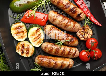 Pfanne mit gegrillten Würstchen, Gemüse und Gewürzen, Blick von oben Stockfoto