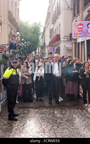 Ein Polizeibeamter in Sevilla, Spanien, steht während der Feierlichkeiten in der Karwoche vor der Menschenmenge. Stockfoto