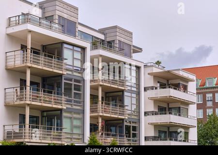 Helsingborg, Schweden; 12. August 2025: Modernes Apartmenthaus mit Balkonen und Glasfassaden, das die städtische Entwicklung und Wohnkultur am Wasser veranschaulicht Stockfoto