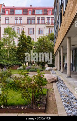 Helsingborg, Schweden; 12. August 2025: Begrünter Innenhof mit moderner Wohnarchitektur, die eine nachhaltige Stadtentwicklung veranschaulicht Stockfoto