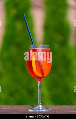 Aperol spritzt Cocktail in Weinglas auf einem Naturhintergrund. Klassischer italienischer aperol-Spritz-Cocktail mit Orangenscheibe. Nahaufnahme. Sommer Stockfoto