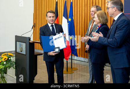 03. Oktober 2025, Saarland, Saarbrücken: Der französische Präsident Emmanuel Macron erhält das Zertifikat und die Medaille für die Ehrendoktorwürde der Universität des Saarlandes. Am 3. Oktober 2025 feiert Deutschland den 35. Jahrestag der deutschen Wiedervereinigung. Foto: Pinter Laszlo/dpa Pool/dpa Stockfoto