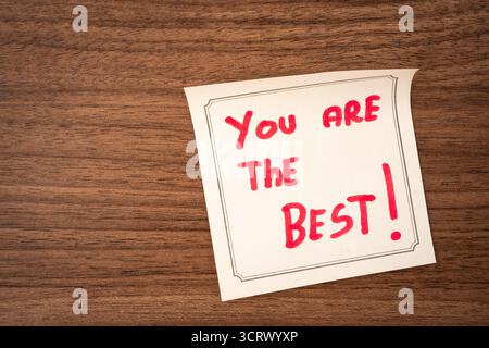 Haftnotizen mit einer positiven Nachricht auf hölzernem Hintergrund. Kreativer Hintergrund. Stockfoto