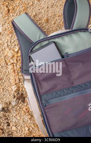 Grüner Kamerarucksack auf dem Boden mit ND-Polarisator-Filtergehäuse in der Tasche auf dem felsigen Wüstenboden. Joshua Tree National Park, Kalifornien. Stockfoto