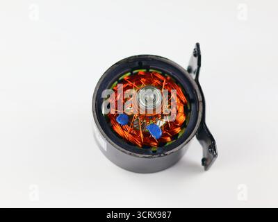 Diese Abbildung zeigt den Stator eines Elektromotors mit aufwändig gewickelten Kupferspulen und einem zentralen Lager. Die leuchtend orangefarbenen Kupferdrähte Stockfoto