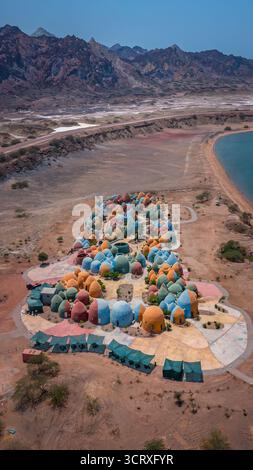 Blick auf lebendige, kuppelförmige Strukturen in der Landschaft, im Kontrast zum trockenen Gelände und den entfernten, zerklüfteten Bergen, Majara Complex, Qeshm, Iran. Stockfoto