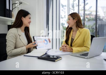 Professionelle asiatische Frauen diskutieren Budget-Präsentation der strategischen Planung von Finanzdaten. Collaboration Meeting für Unternehmenswachstum. Stockfoto