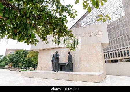 Dwight D Eisenhower Memorial Statuen Washington DC // WASHINGTON DC – das Dwight D. Eisenhower Memorial zeigt Bronzestatuen von Sergej Eylanbekov. Eine Statue stellt den 34. US-Präsidenten als Staatsmann dar. Zitate aus seiner zweiten Antrittsrede sind an der Marmorwand dahinter eingraviert. Ein großer Wandteppich aus Edelstahl wurde von Frank Gehry entworfen und zeigt die Landschaft von Kansas. Die im September 2020 eingeweihte Gedenkstätte ehrt Eisenhowers militärisches und präsidiales Erbe (1953–1961). Stockfoto