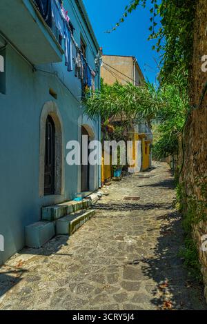 Via delle Taverne in Venafro, einer schmalen Gasse im historischen Zentrum Italiens, die von einer kopfsteingepflasterten Straße und farbenfrohen blauen und gelben Häusern geprägt ist. Stockfoto