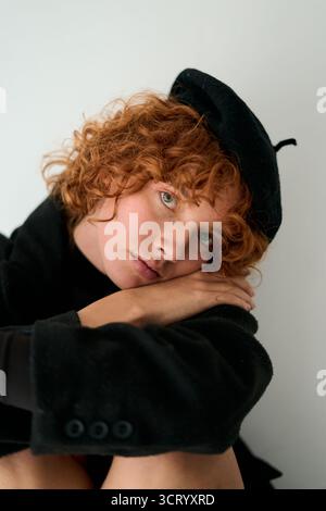 Eine junge Frau mit rotem lockigem Haar, die Baskenmütze trägt Stockfoto