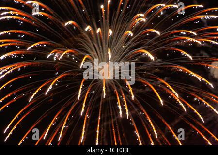 Feuerwerk Nachthimmel, Feier in der Abenddämmerung, Funken rot und orange mit Rauch Stockfoto
