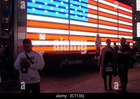 New York, Usa. Oktober 2025. Menschen werden vor einer Beleuchtungsinstallation der amerikanischen Flagge am Times Square, Manhattan, New York City, gesehen. Quelle: SOPA Images Limited/Alamy Live News Stockfoto
