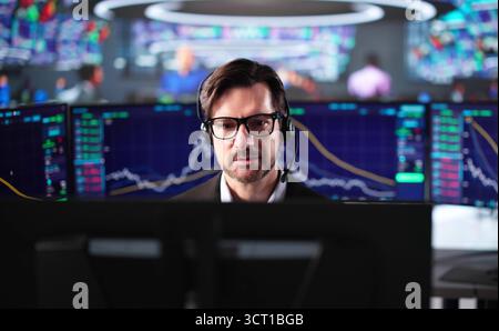 Senior Stock Trader Mann, Der Mehrere Computermonitore In Büroumgebung Verwendet. Stockfoto