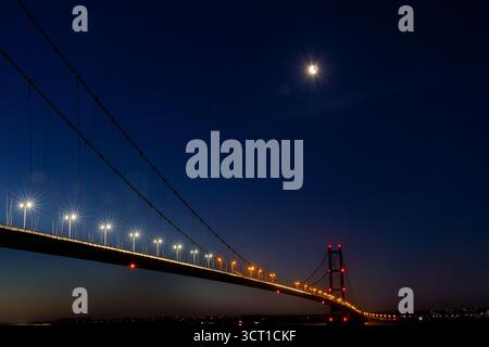 Humber Bridge beleuchtet bei Nacht unter Mondsichel Stockfoto
