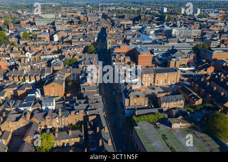 Blick aus der Vogelperspektive auf die Lower Bridge Street in Chester, gesäumt von historischen Dächern und Gebäuden aus rotem Backstein. Stockfoto