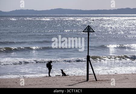 Das Sonnenlicht reflektiert den Ozean und schafft Silhouetten an der Küste von Sidmouth, Devon an der Südküste Englands. Stockfoto